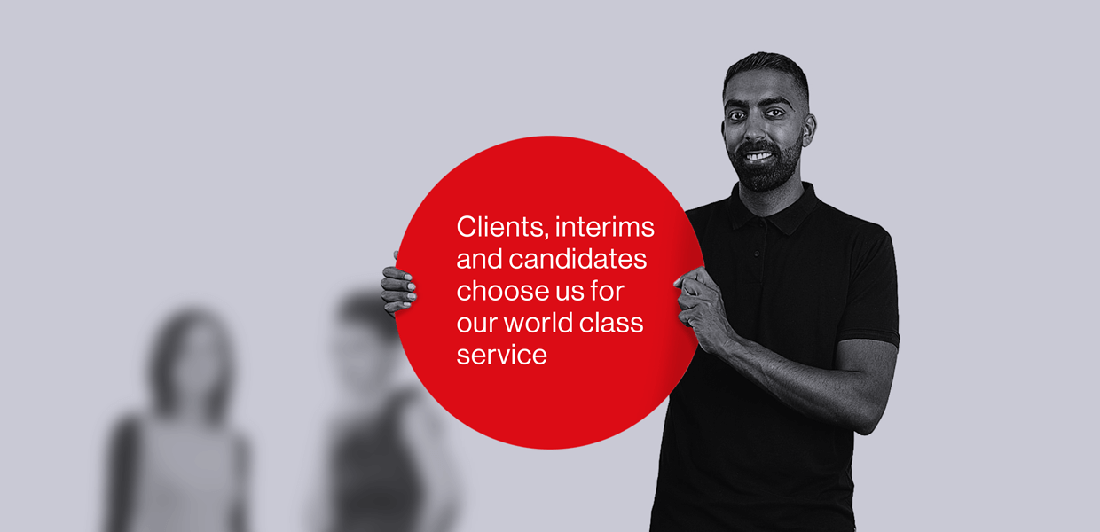 A man is holding a large red circle with white text on top that reads: Clients, interims and candidates choose us for our world class service
