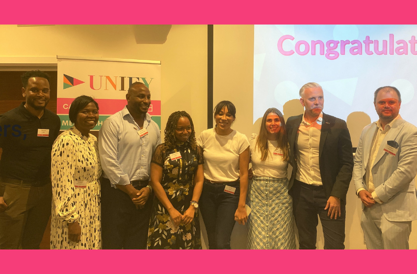 Photo showing 8 people standing in front of Caongratulations - graduates and speakers from 2023 LeadershipNOW! programme