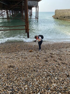 person litter picking under brighton pier