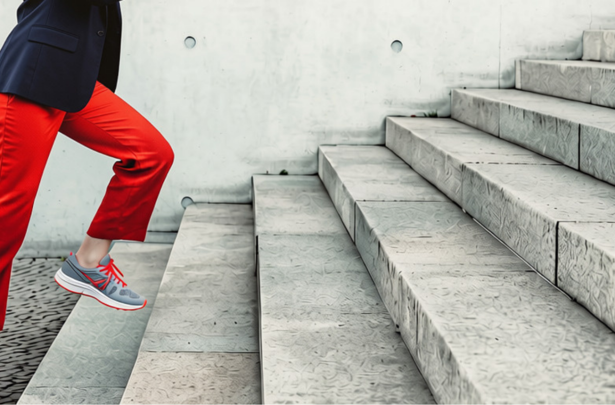 Woman in red trousers running up concrete stairs